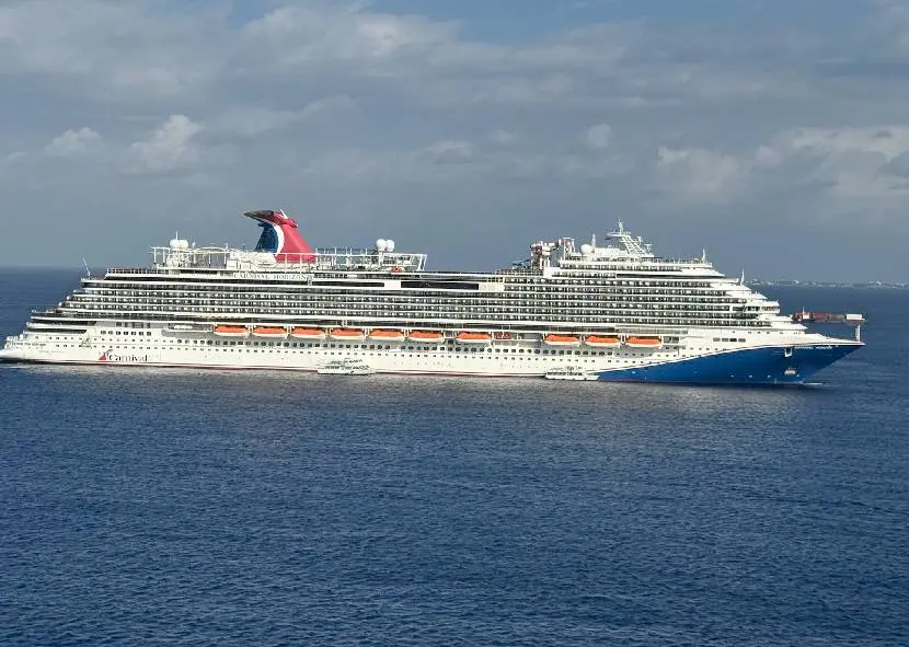 A Carnival cruise ship sailing across blue water